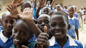 Happy ugandan children waving and giving thumbs up